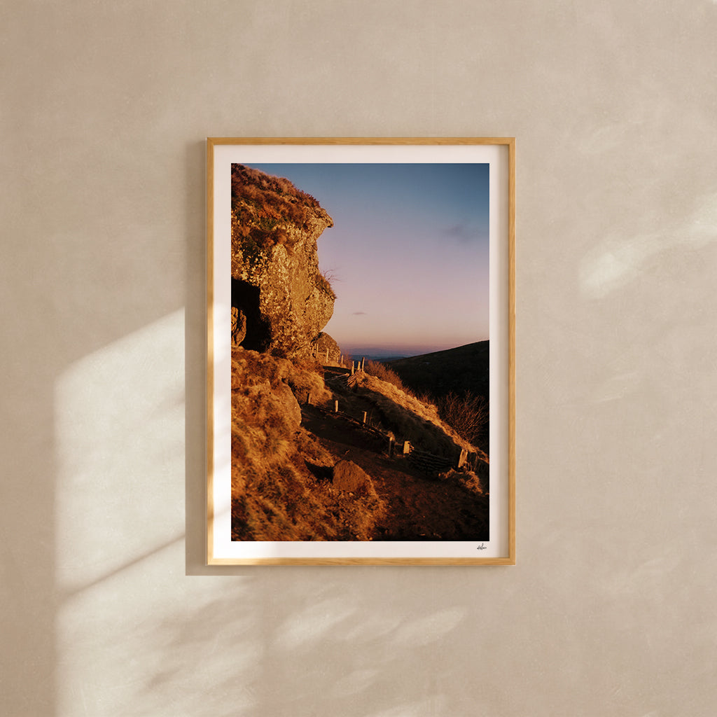 Golden winter light on a volcanic rock at the Puy de Clierzou, Auvergne, France — analog film photography print framed in natural oak